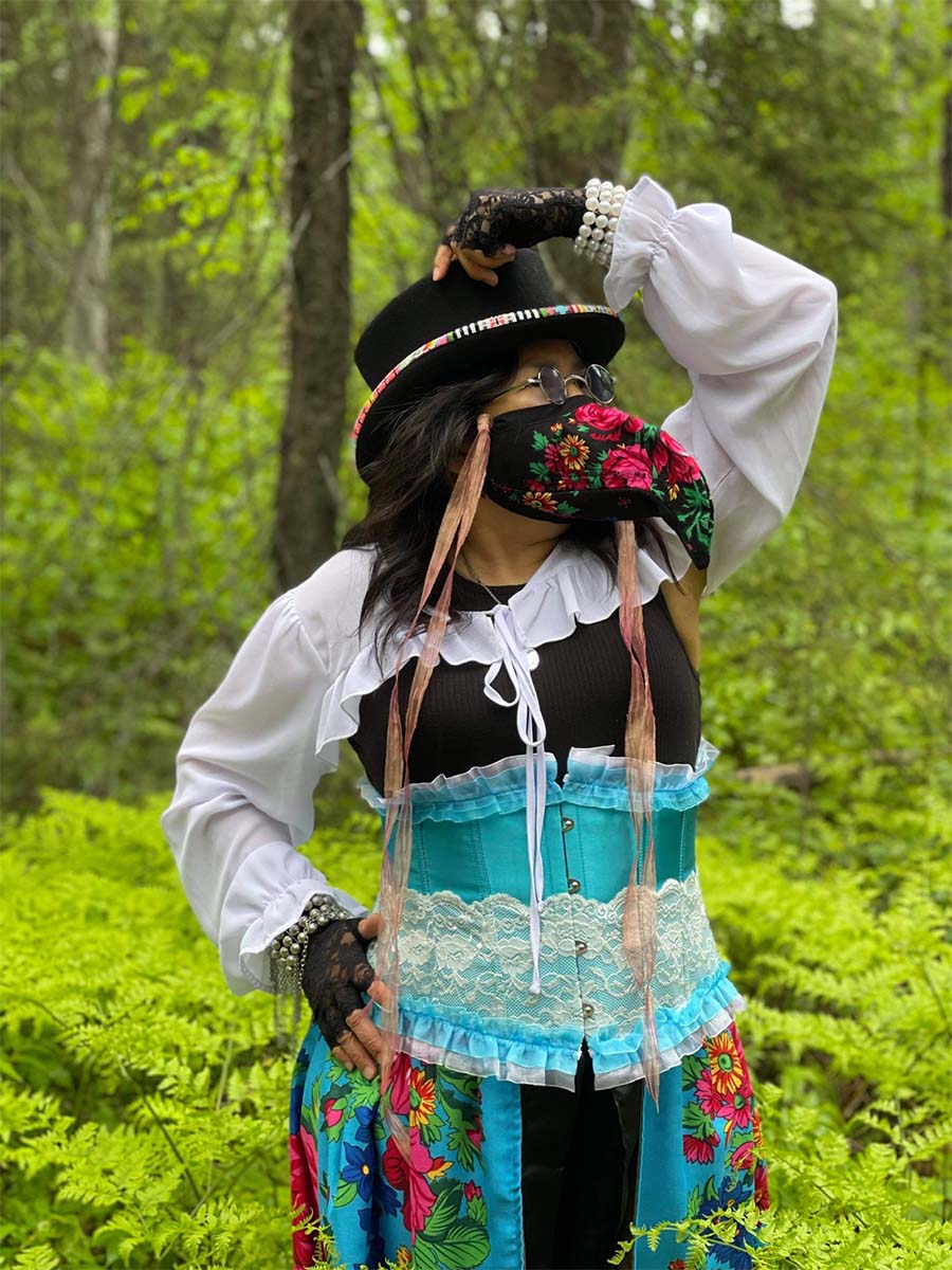 Delores wearing a black floral plague doctor mask